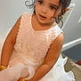 Ayat is registered to the contest to win money with this photo: child, girl, dress, white_dress, pearl_decorations, bracelets, hair_tie, indoor, floor, vent, curly_hair, cute, portrait, young_child, fashion, accessories, skin, person, standing, decorative