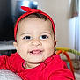 Rita participe au concours pour gagner de l'argent avec cette photo : baby, child, smiling, red_headband, red_clothing, indoors, face, portrait, cute, happy, person, infant, closeup, cheeks, tongue, jewelry, earrings, home, soft_lighting, playful