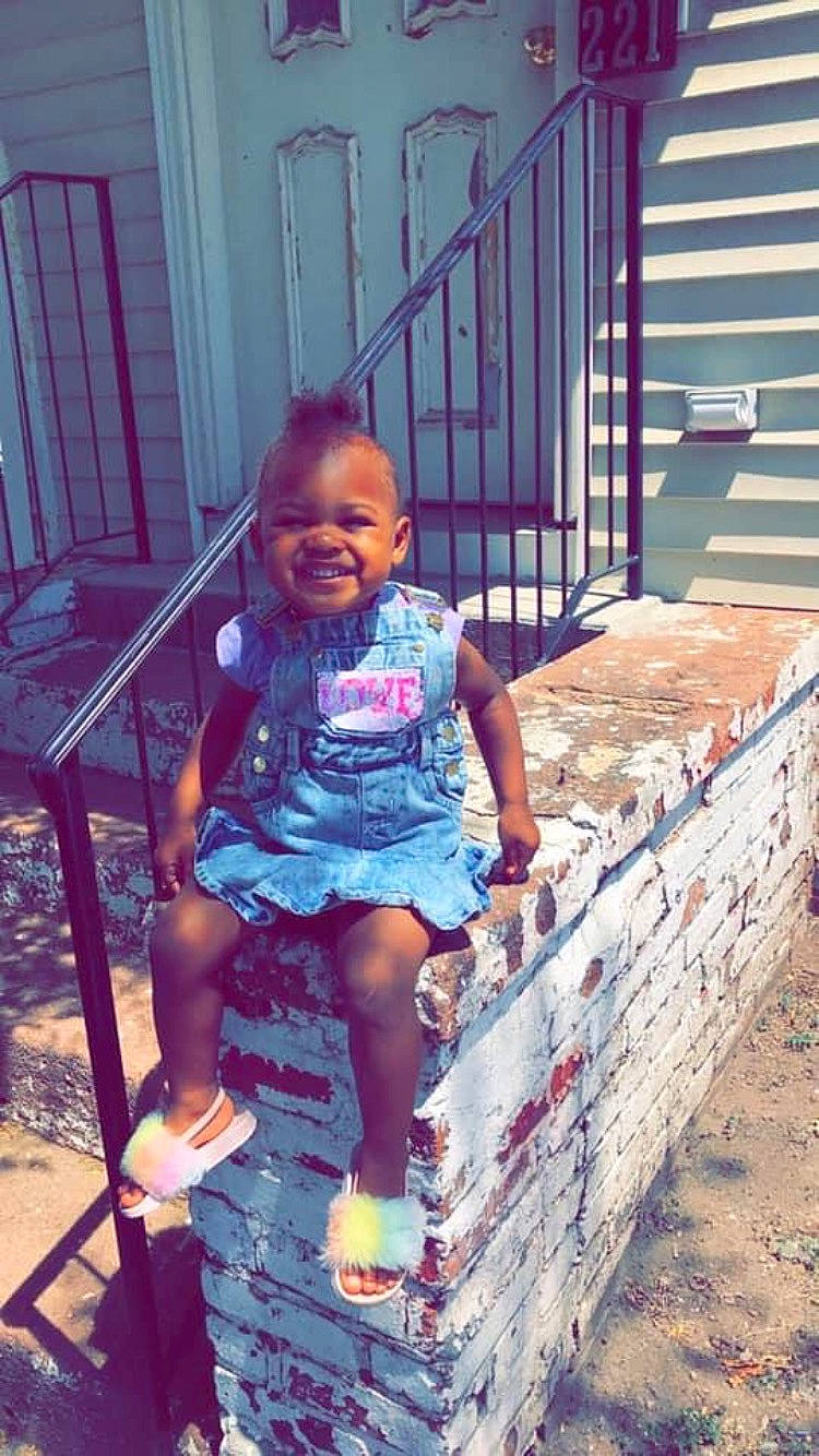 Jaylynn is registered to the contest to win money with this photo: beauty, child, door, electric_blue, flip_flops, fun, happy, human_leg, joy, leg, leisure, light, magenta, person, pink, sandal, sitting, smile, t_shirt, thigh