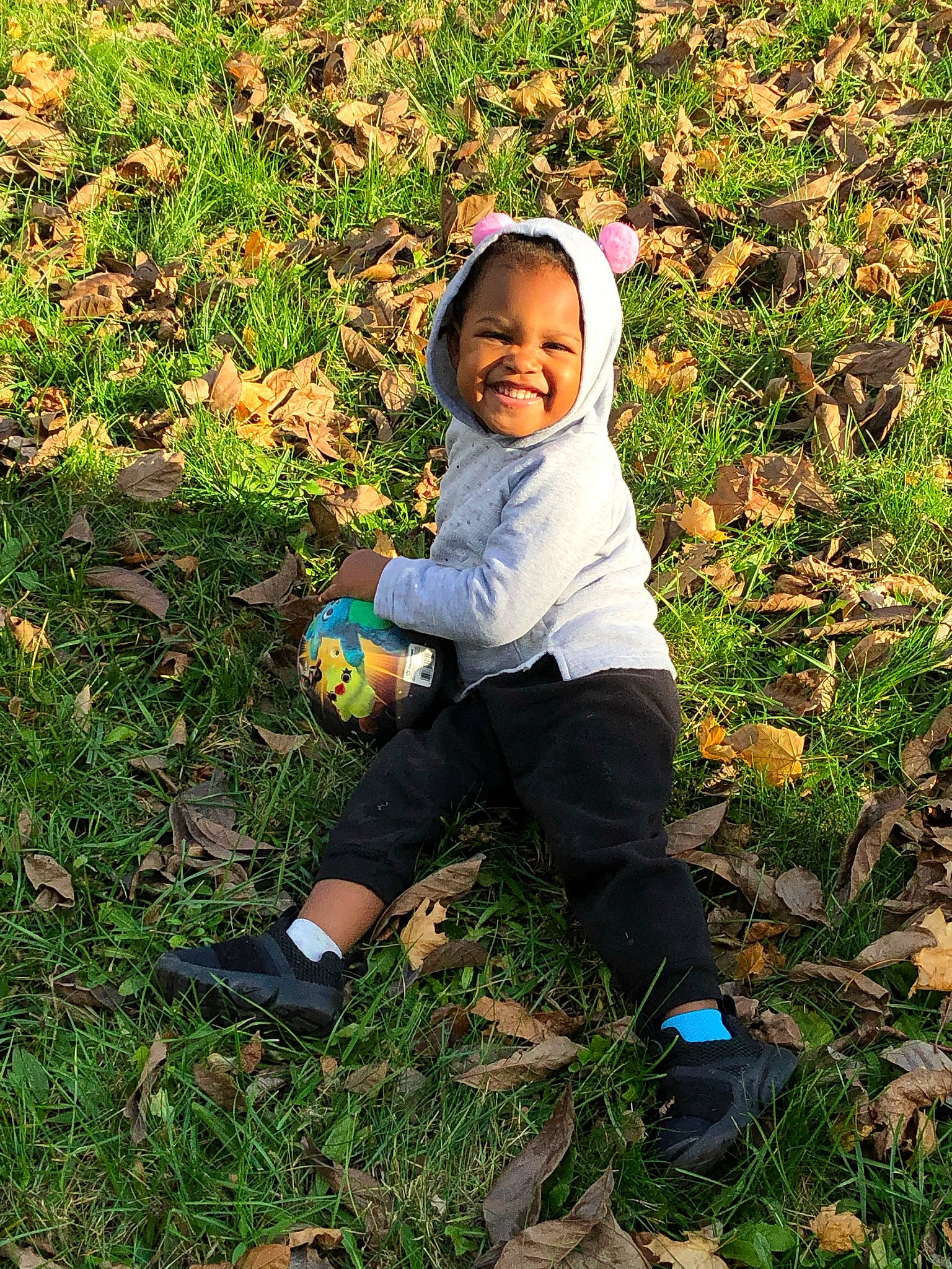 Jaylynn is registered to the contest to win money with this photo: baby, baby_toddler_clothing, ball, child, football, fun, grass, grass_family, grassland, groundcover, happy, joy, leaf, people_in_nature, person, plant, shoe, sitting, smile, sneakers