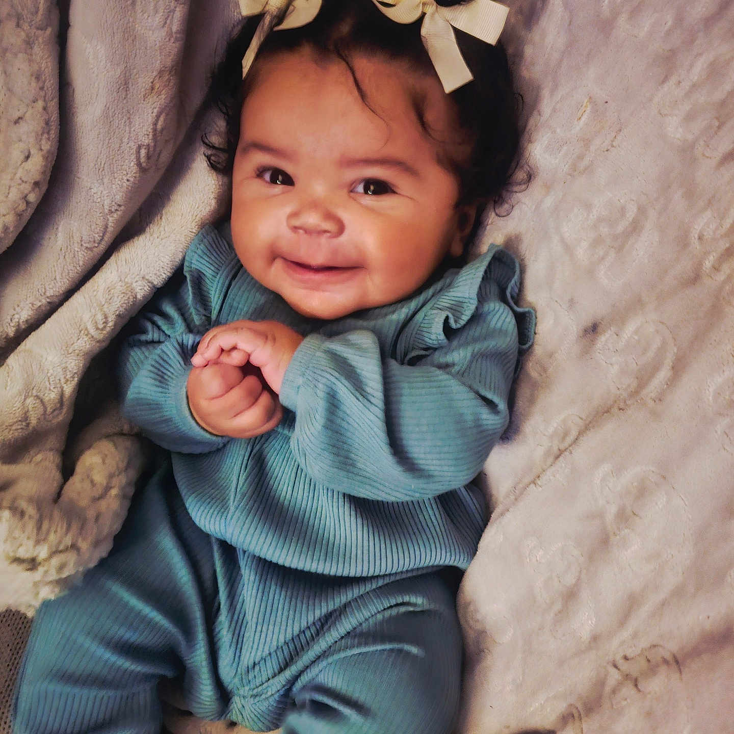 Pricilla joined the competition — help win amazing prizes! adorable, baby, blanket, blue_outfit, bows, child, clothing, cozy, cute, hair_accessory, hands, happy, indoor, infant, infant_fashion, lying_down, portrait, smiling, soft_texture, warm