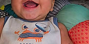 Miles is registered to the contest to win money with this photo: baby, smiling, infant, cute, shirt, text, captain_crabby_pants, cushion, colorful, happy, face, child, indoors, clothing, closeup, portrait, soft, comfortable, playful, joyful