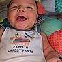 baby, smiling, infant, cute, shirt, text, captain_crabby_pants, cushion, colorful, happy, face, child, indoors, clothing, closeup, portrait, soft, comfortable, playful, joyful