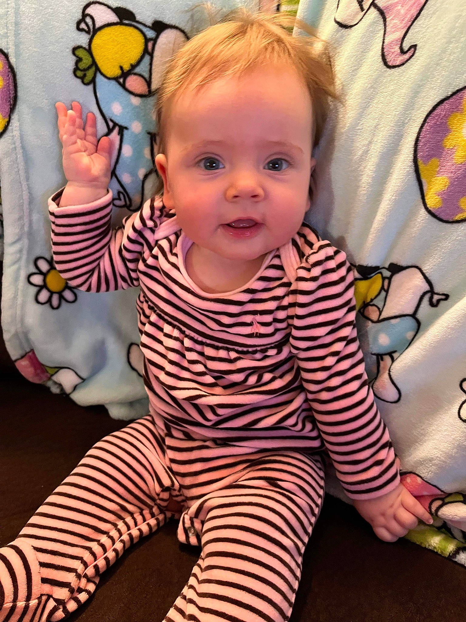 Emma is registered to the contest to win money with this photo: arm, baby, baby_toddler_clothing, cheek, child, cool, eye, facial_expression, finger, floor, flooring, happy, mouth, nose, organ, person, skin, sleeve, smile, standing