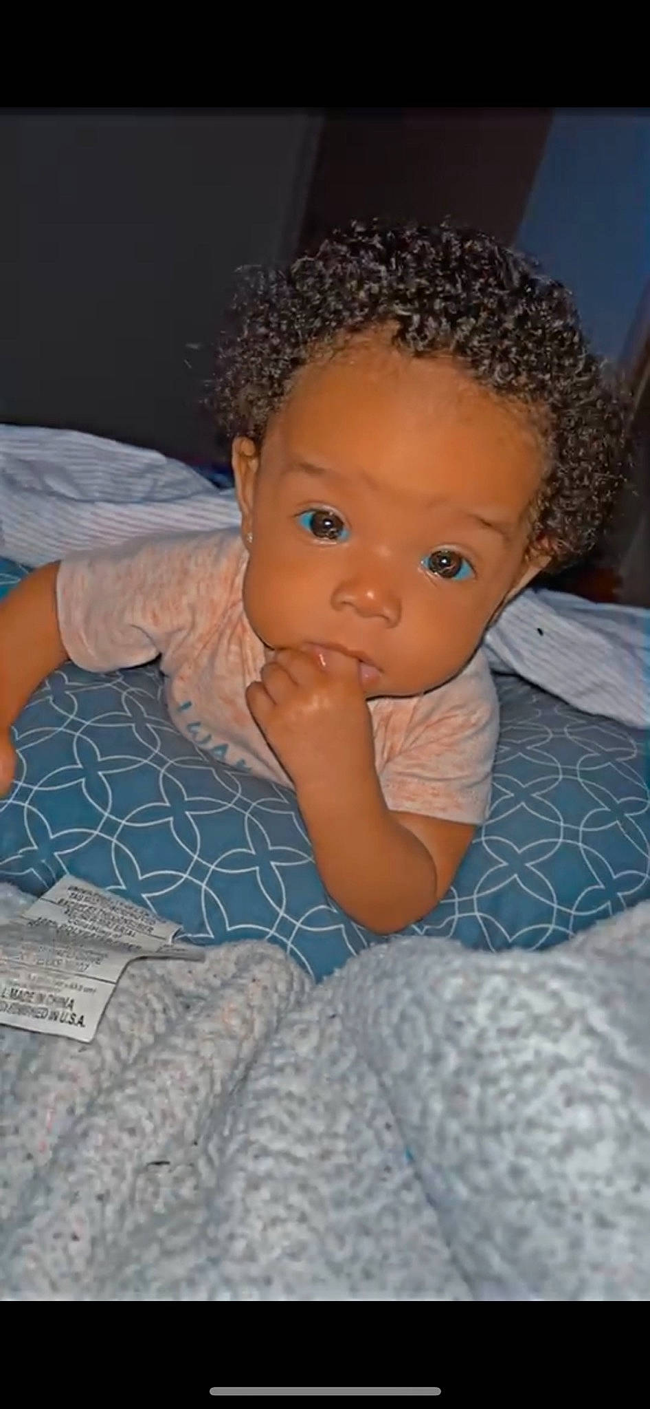 Amoura is registered to the contest to win money with this photo: afro, baby, baby_toddler_clothing, bed, cheek, child, comfort, electric_blue, flooring, fun, iris, jheri_curl, linens, lip, nose, ringlet, room, skin, thumb, toddler