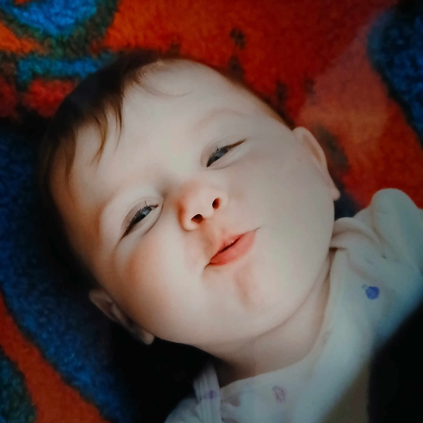 Brixlee is registered to the contest to win money with this photo: baby, infant, face, expression, playful, carpet, colorful, child, portrait, closeup, cute, young, person, lying_down, funny_face, indoors, skin, clothing, head, smiling