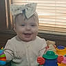 Brixlee is registered to the contest to win money with this photo: baby, child, bow, smiling, toy, activity_center, indoor, window, blinds, colorful, play, infant, cute, happy, clothing, face, person, furniture, hand, seat