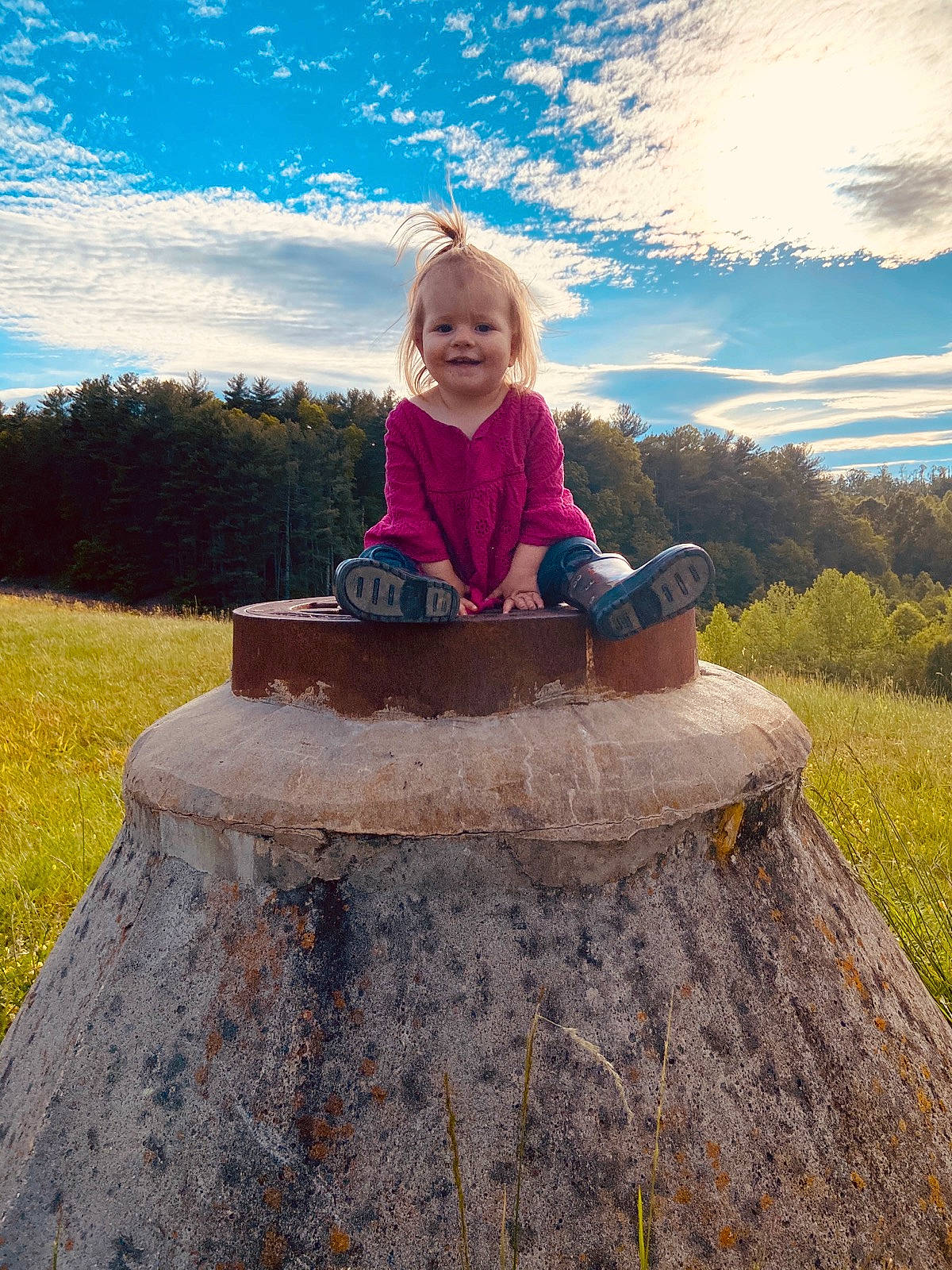 Nicole is registered to the contest to win money with this photo: blond, child, cloud, grass, happy, joy, landscape, mountain, person, photography, recreation, rock, sitting, sky, smile, spring, summer, table, toddler, tree
