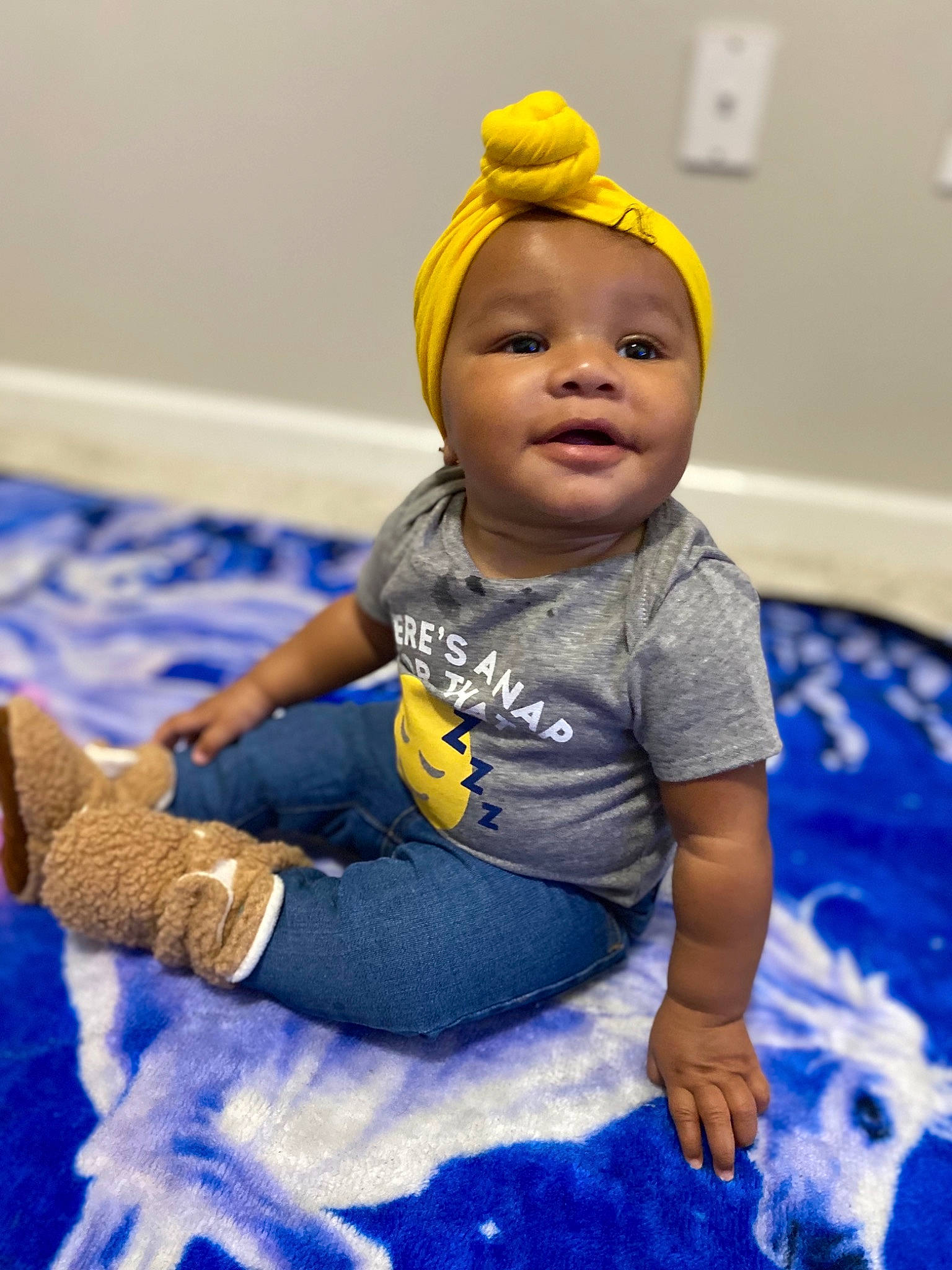 Joni is registered to the contest to win money with this photo: arm, baby, baby_toddler_clothing, beauty, blue, child, facial_expression, flooring, fun, happy, head, human_body, leisure, person, product, purple, skin, sleeve, smile, sock