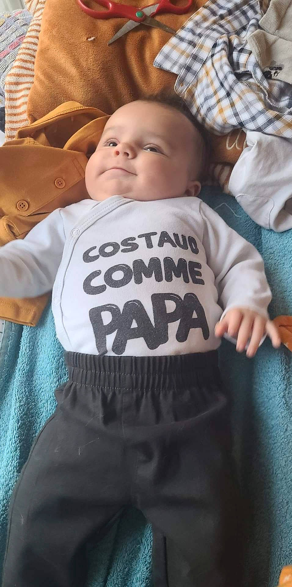 Enzo a rejoint le concours — aidez-le/la à gagner de superbes lots ! baby, baby_products, baby_toddler_clothing, cheek, child, comfort, facial_expression, fur, happy, head, linens, pattern, person, room, sitting, skin, sleeve, smile, t_shirt, textile