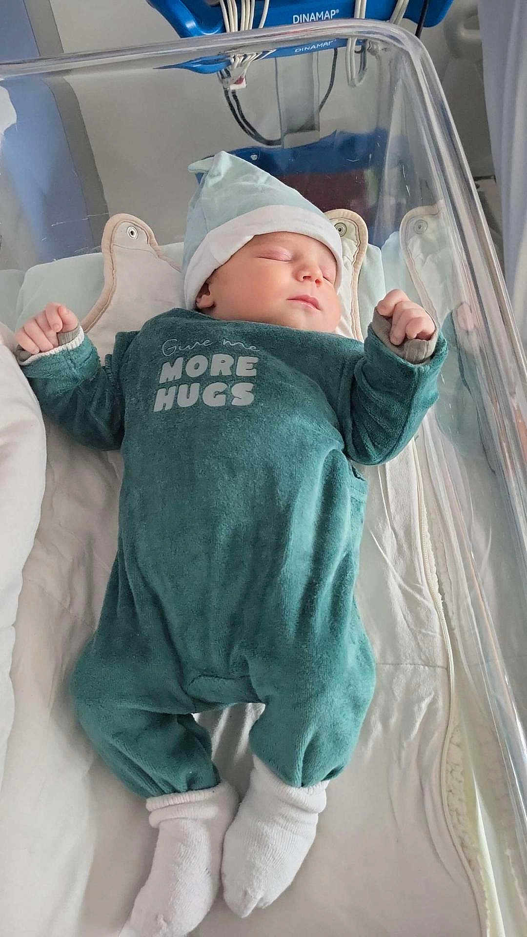 Izac a rejoint le concours — aidez-le/la à gagner de superbes lots ! newborn, baby, sleeping, onesie, hat, socks, hospital, bassinet, infant, cozy, peaceful, child, cute, clothing, bed, blanket, resting, soft, person, portrait