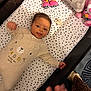 baby, crib, polka_dot, onesie, pacifier, toy, stuffed_animal, hand, smiling, infant, bed, child, sleepwear, striped_socks, fabric, person, cute, colorful, indoor, playpen