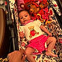 Freya is registered to the contest to win money with this photo: baby, infant, stroller, plush_toys, hand, patterned_fabric, teddy_bear, red_shorts, white_shirt, floral_pattern, bird_pattern, cute, child, person, lying_down, indoor, colorful, soft_toys, baby_clothing, toddler