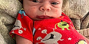 Cashton is registered to the contest to win money with this photo: baby, blanket, child, cozy, cute, expression, face, head, indoors, infant, lying_down, monsters, newborn, onesie, person, red_clothing, skin, sleepwear, small, soft_texture