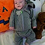 baby, infant, child, plush_toys, jack_o_lantern, ghost_pillow, teddy_bear, grey_tracksuit, bed, soft_toys, cute, lying_down, hoodie, pants, barefoot, indoors, holiday_theme, halloween, smiling, cozy