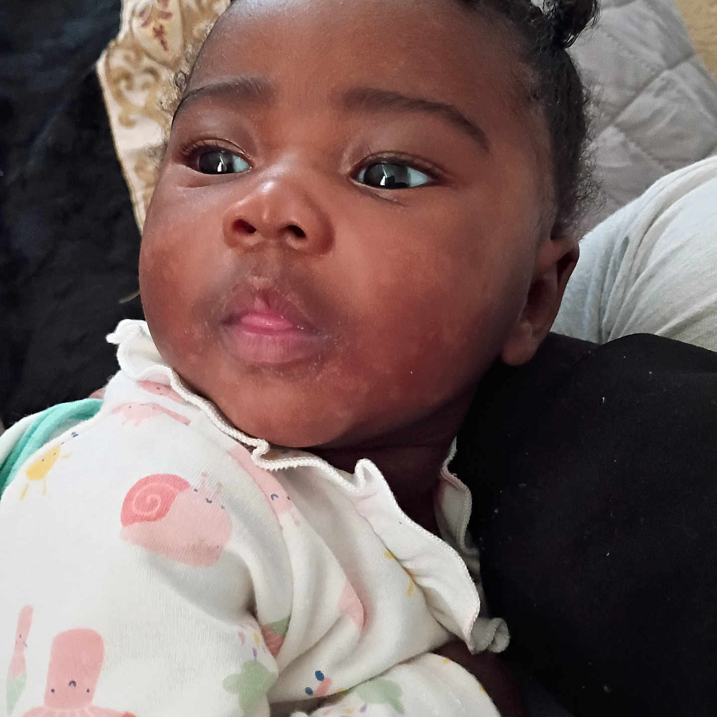 Cimani is registered to the contest to win money with this photo: baby, child, infant, face, eyes, hair, onesie, clothing, pattern, cute, portrait, indoors, resting, skin, expression, small_hands, cozy, closeup, person, young