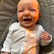 Penelope joined the competition — help win amazing prizes! baby, baby_seat, child, clothing, cushion, cute, expression, fist, gray_fabric, happy, human, indoor, infant, onesie, pink_pattern, portrait, seat, smile, white_clothing, young