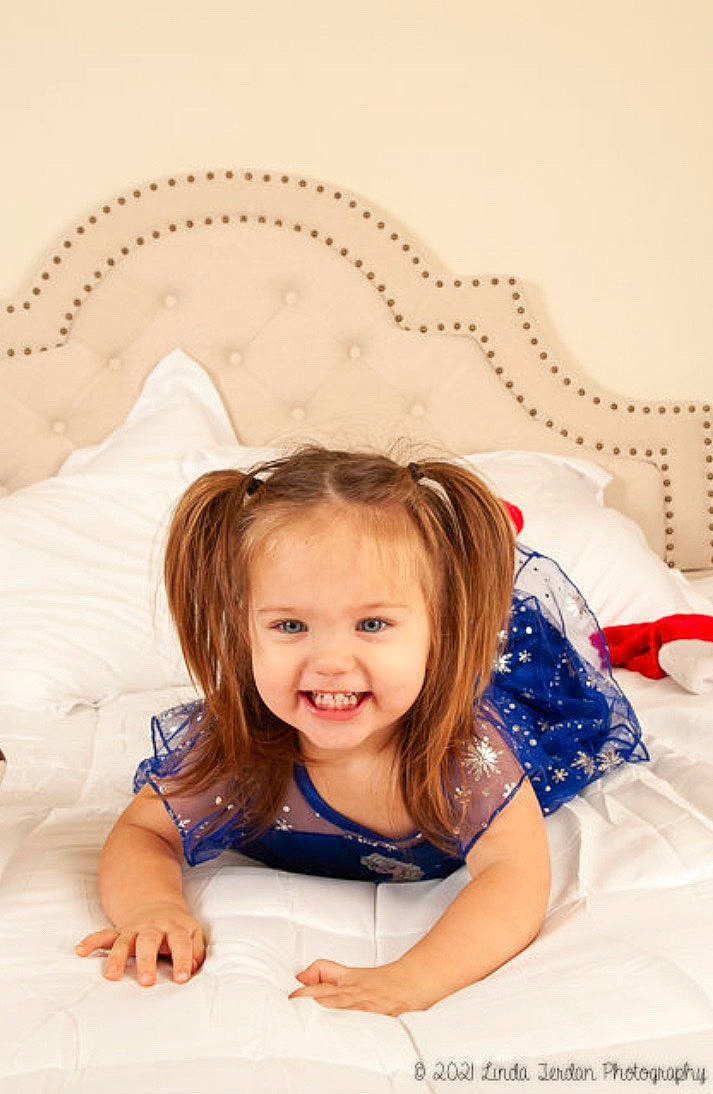 Sloane joined the competition — help win amazing prizes! blond, child, dress, face, facial_expression, finger, flash_photography, fun, happy, headpiece, iris, jewellery, joy, pattern, person, product, room, sitting, skin, smile