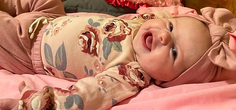 Harper is registered to the contest to win money with this photo: baby, beauty, cheek, comfort, eye, eyelash, face, happy, headwear, human, human_body, lip, mammal, mouth, nose, person, pink, skin, sleeve, smile