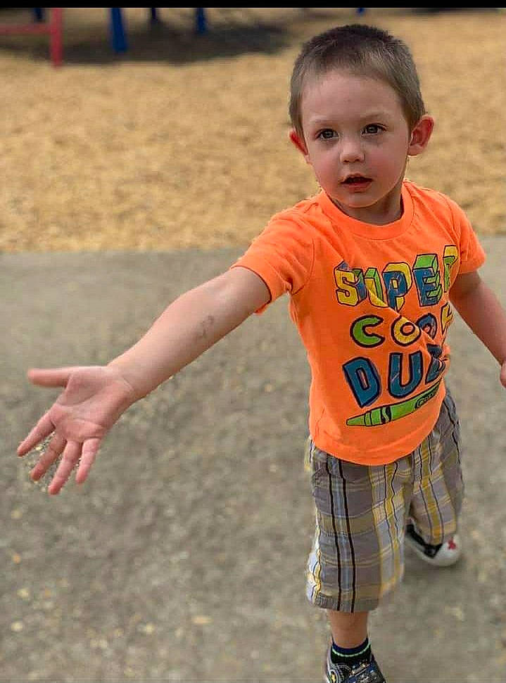 Keith is registered to the contest to win money with this photo: baby_toddler_clothing, child, face, fun, gesture, grass, hairstyle, happy, head, human_leg, leisure, people_in_nature, person, recreation, shorts, skin, sleeve, t_shirt, thumb, toddler