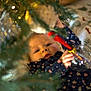 baby, blanket, celebration, child, christmas_tree, cozy, curious, cute, decorations, face, festive, holiday, holiday_season, indoor, infant, ornament, person, reaching, seasonal, smiling