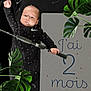 baby, infant, onesie, nike, fishing_rod, green_leaves, milestone_card, text, black_clothing, portrait, indoor, cute, child, hand, face, young, two_months, celebration, plant, growth