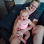 Dawn is registered to the contest to win money with this photo: baby, casual, cdshelf, chair, child, family, furniture, glasses, happy, holding, home, indoor, laughing, person, pink_clothing, seated, skin, smiling, toycar, woman