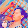 Pearl participe au concours pour gagner de l'argent avec cette photo : bedroom, blue, casual, companion, cozy, cute, dog, heart, human, indoor, nap, orange, person, pillow, plaid_pattern, portrait, relaxation, resting, sleeping, text_overlay