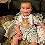 baby, child, infant, smiling, bib, pajamas, carpet, blanket, cushion, indoor, cozy, cute, happy, person, sitting, floor, animal_print, home, soft_lighting, playful