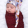 Maya is registered to the contest to win money with this photo: baby, sleeping, infant, wrapped, blanket, lace, hat, floral, face, closed_eyes, peaceful, soft, portrait, newborn, cute, cozy, child, lying_down, white_background, adorable
