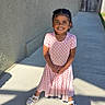 backyard, building, child, dress, fence, girl, happy, house, outdoor, photography, pink_dress, portrait, sandals, shadows, sidewalk, smiling, standing, summer, sunlight, windows
