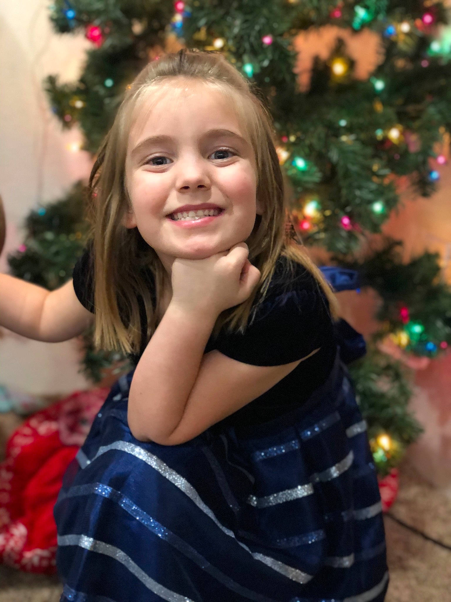 Rhyllie is registered to the contest to win money with this photo: christmas_decoration, christmas_ornament, christmas_tree, facial_expression, fun, hair, hairstyle, happy, head, holiday_ornament, iris, joy, light, ornament, person, photograph, plant, smile, standing, toddler