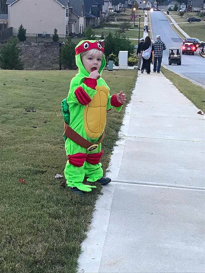 Talon is registered to the contest to win money with this photo: child, costume, fun, grass, green, mascot, person, personal_protective_equipment, play, recreation, toddler, tree