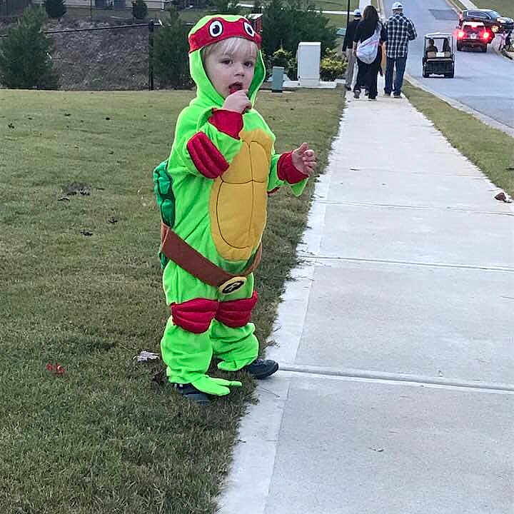 Talon is registered to the contest to win money with this photo: child, costume, fun, grass, green, mascot, person, personal_protective_equipment, play, recreation, toddler, tree