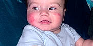 Lucas Harrison joined the competition — help win amazing prizes! baby, child, infant, face, cheeks, red_cheeks, skin, arm, clothing, onesie, person, sitting, curious, expression, indoors, blanket, fabric, hair, portrait, cute