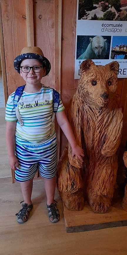 Lioris participe au concours pour gagner de l'argent avec cette photo : art, artifact, big_cats, brown_bear, cap, carnivore, clothing, fawn, felidae, grizzly_bear, hat, headwear, joy, kodiak_bear, person, sandal, sculpture, smile, statue, terrestrial_animal