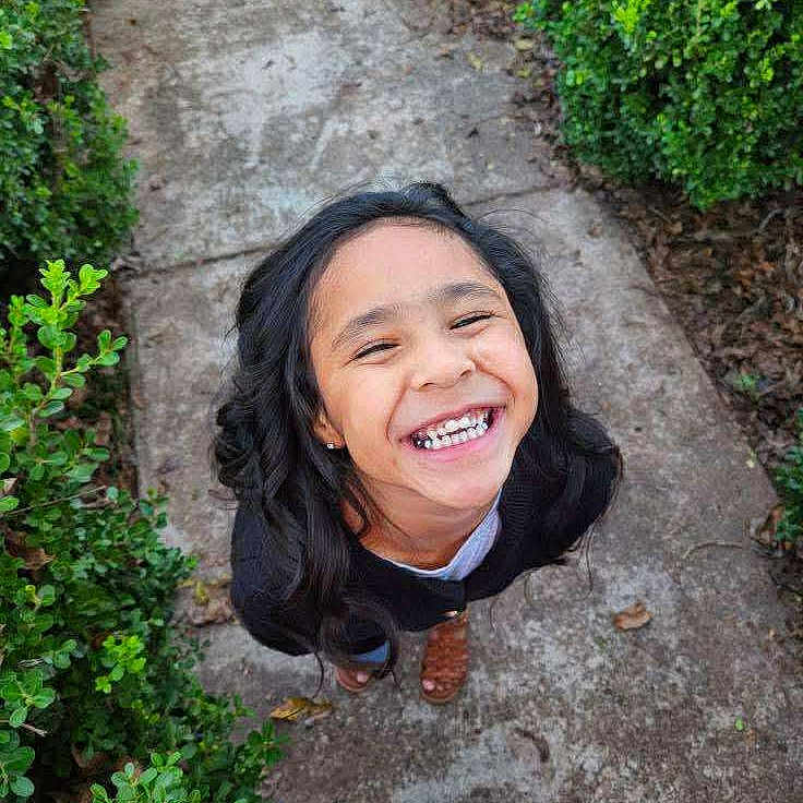 Jadiah joined the competition — help win amazing prizes! bushes, casual_clothing, child, cute, daylight, feet, girl, greenery, happy, joy, long_hair, nature, outdoor, path, person, portrait, sandals, sidewalk, smiling, young