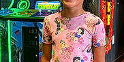 Jadiah joined the competition — help win amazing prizes! child, girl, arcade, arcade_game, smiling, pink_clothing, princess_print, tooth_gap, indoor, wooden_floor, gaming, bright_colors, neon_lights, happy, short_sleeve, standing, casual_wear, entertainment, fun, portrait