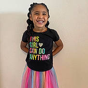 Jadiah joined the competition — help win amazing prizes! child, girl, smiling, braids, colorful_skirt, tshirt, standing, happy, portrait, indoor, wall, fashion, clothing, casual, cute, person, youth, positive_message, joy, confidence