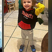 Ryan Ashton joined the competition — help win amazing prizes! child, smiling, indoor, hoodie, sweatpants, sneakers, tile_floor, wooden_stool, books, living_room, playful, young_child, casual_clothing, happy, person, portrait, standing, colorful_clothing, cozy, home