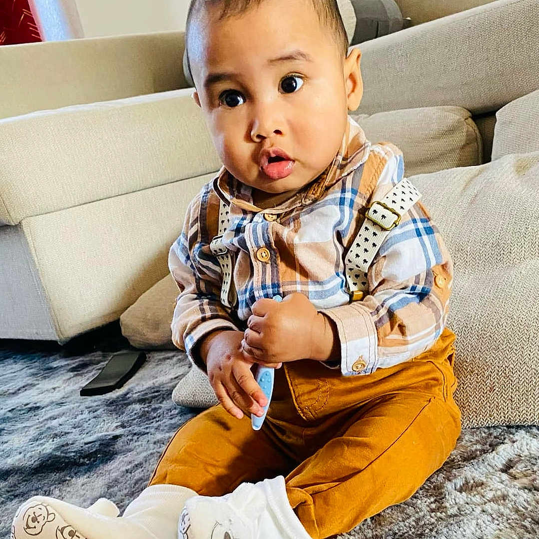 Maëlo a rejoint le concours — aidez-le/la à gagner de superbes lots ! blackhair, boy, child, clothing, couch, electronics, face, furniture, hair, head, hosiery, jeans, male, mobilephone, pants, person, phone, sitting, sleeve, sock
