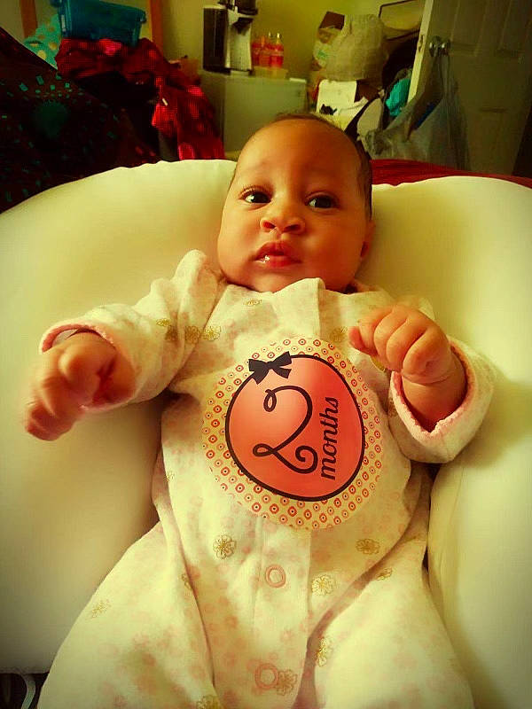 Alyssia is registered to the contest to win money with this photo: baby, baby_toddler_clothing, cheek, child, chin, comfort, eye, finger, hand, happy, head, human_body, mouth, nose, person, product, sitting, skin, sleeve, stomach