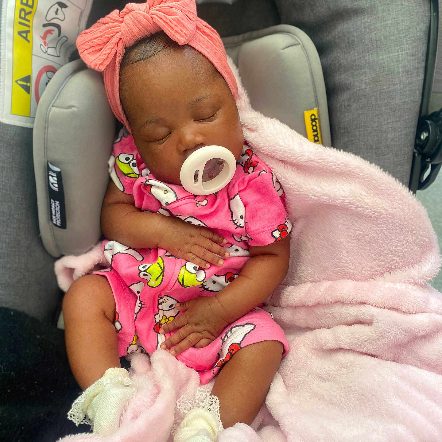 Zakyra is registered to the contest to win money with this photo: accessory, adorable, baby, blanket, car_seat, child, clothing, comfort, cute, headband, indoors, infant, newborn, pacifier, peaceful, pink_outfit, resting, sleeping, soft_texture, toddler
