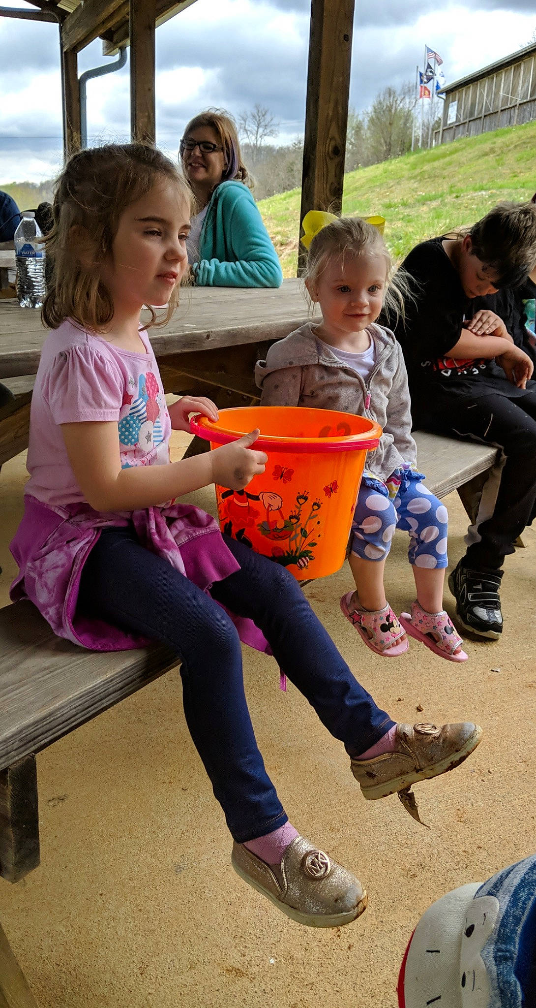 Genesis is registered to the contest to win money with this photo: adaptation, child, event, face, footwear, fun, grass, happy, joy, lap, leisure, person, plant, recreation, sandal, shoe, shorts, sitting, sneakers, t_shirt