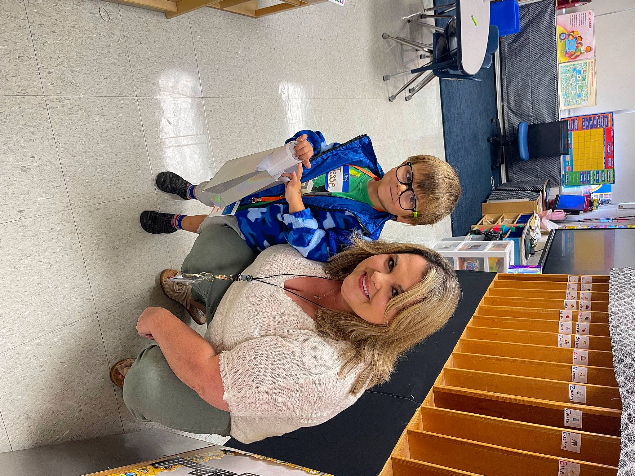 Jesse is registered to the contest to win money with this photo: child, comfort, elbow, electric_blue, engineering, flooring, fun, happy, indoor_games_and_sports, joy, knee, leisure, person, room, sitting, smile, t_shirt, thigh, wood, wrist