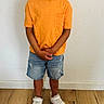 Selyan a rejoint le concours — aidez-le/la à gagner de superbes lots ! child, boy, orange_tshirt, denim_shorts, white_sneakers, standing, indoor, wooden_floor, white_wall, casual_clothing, portrait, person, smiling, fashion, cute, young, feet, hands, looking_at_camera, full_body
