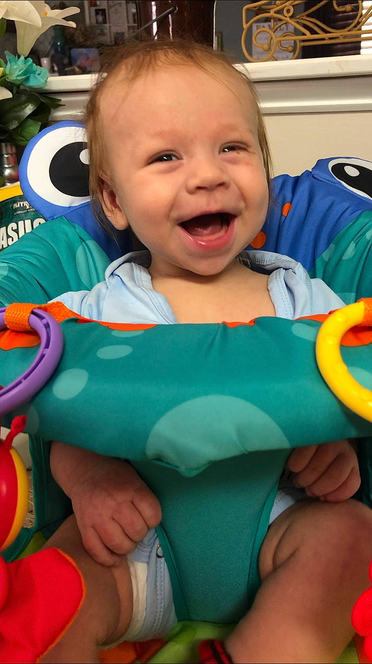 Linden is registered to the contest to win money with this photo: arm, baby_products, blue, boy, child, day, emotion, eye, facial_expression, fun, infant, mouth, organ, person, play, product, sitting, skin, smile, toddler