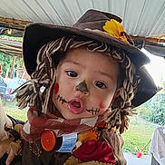 Francia Adalet is registered to the contest to win money with this photo: child, toddler, costume, scarecrow, face_paint, hat, yarn_hair, flower, outdoor, curious, baby_gear_tag, hand, person, portrait, fall, festival, cute, dress_up, holiday, headwear