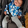 toddler, child, stroller, blue_jacket, gray_pants, white_socks, smiling, baby, indoor, wooden_floor, seatbelt, clothing, happy, casual_wear, person, portrait, cute, baby_wear, seated, infant