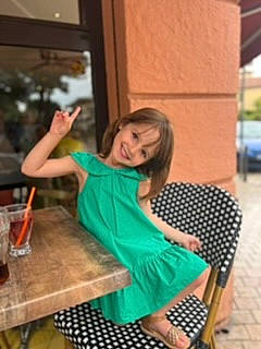 Milla participe au concours pour gagner de l'argent avec cette photo : chair, fashion_design, fun, happy, human_leg, joy, kitchen_dining_room_table, leisure, pattern, person, play, room, sandal, sitting, sleeve, smile, street_fashion, t_shirt, table, thigh